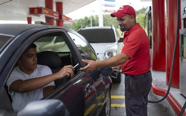 Tiền mất giá, người dân Venezuela dùng kẹo, thuốc lá...để mua xăng - Ảnh 1.