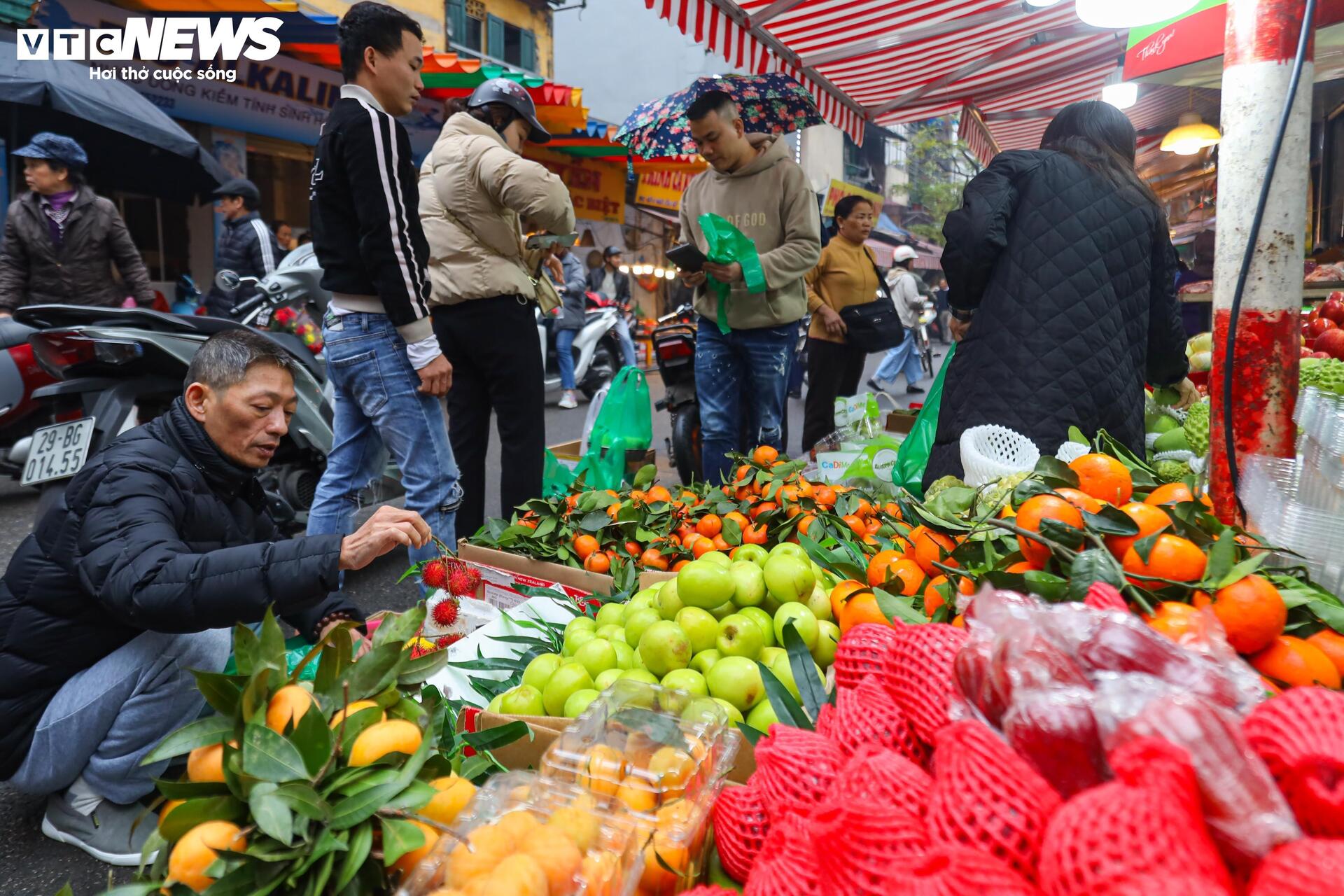 Người Hà Nội đội mưa sắm đồ cúng rằm tháng Giêng, giá hoa tươi vẫn đắt ngang Tết - Ảnh 13