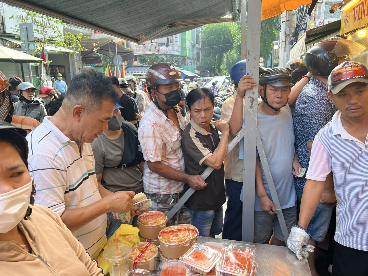 Người dân xếp hàng dài từ sáng sớm chờ mua heo, vịt quay cúng Tết Đoan Ngọ - Ảnh 10