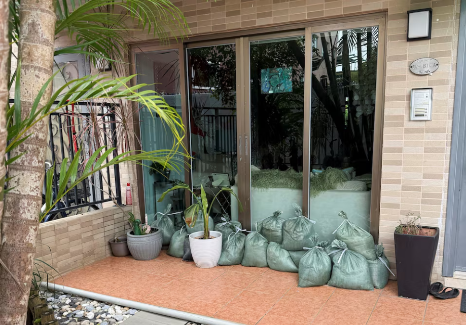 Các thành phố “đóng cửa”, nín thở trước siêu bão Ragasa: Người dân dán chặt cửa kính, chặn bao cát trước nhà, càn quét siêu thị tích trữ đồ - Ảnh 8