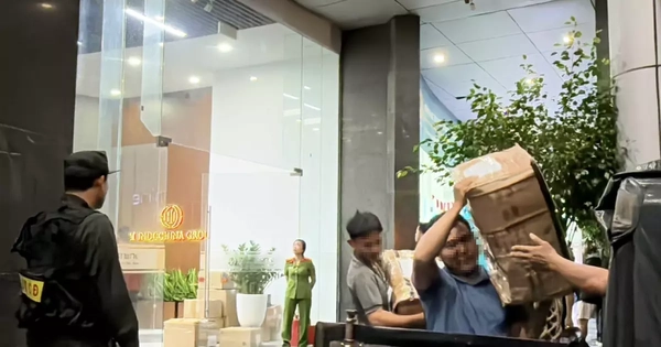 Cảnh sát vận chuyển nhiều thùng niêm phong ra khỏi tòa nhà có trụ sở công ty Shark Bình