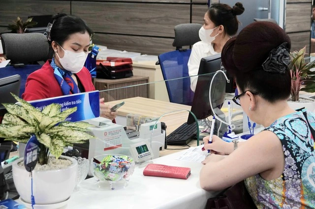 Người dân, doanh nghiệp vẫn ùn ùn gửi tiền vào ngân hàng - Ảnh 1