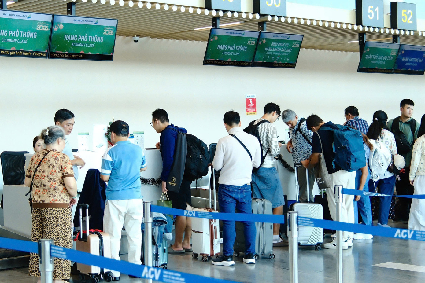 Dòng người nghỉ Tết bắt đầu đổ về sân bay Tân Sơn Nhất - Ảnh 1