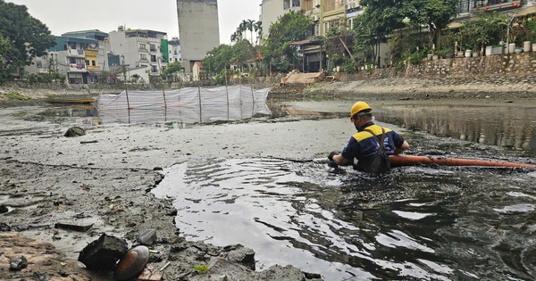 Công nhân ngâm mình trong nước bẩn, nạo vét cống, sông Hà Nội ngày 29 Tết